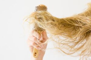 Woman Brushing Frizzy Dry Hair