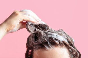 Woman Lathering Shampoo On Head