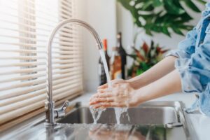 Women Washing Hands In Kitchen Sink